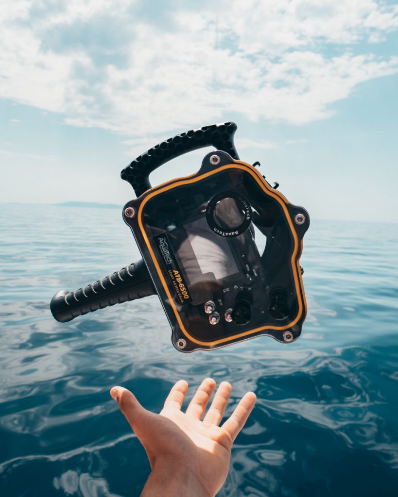 Person holding underwater camera on Komodo cruise